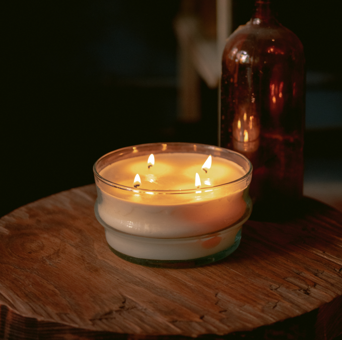 Dark Room Lit by Glass Candle With Four Wicks on Wooden Table