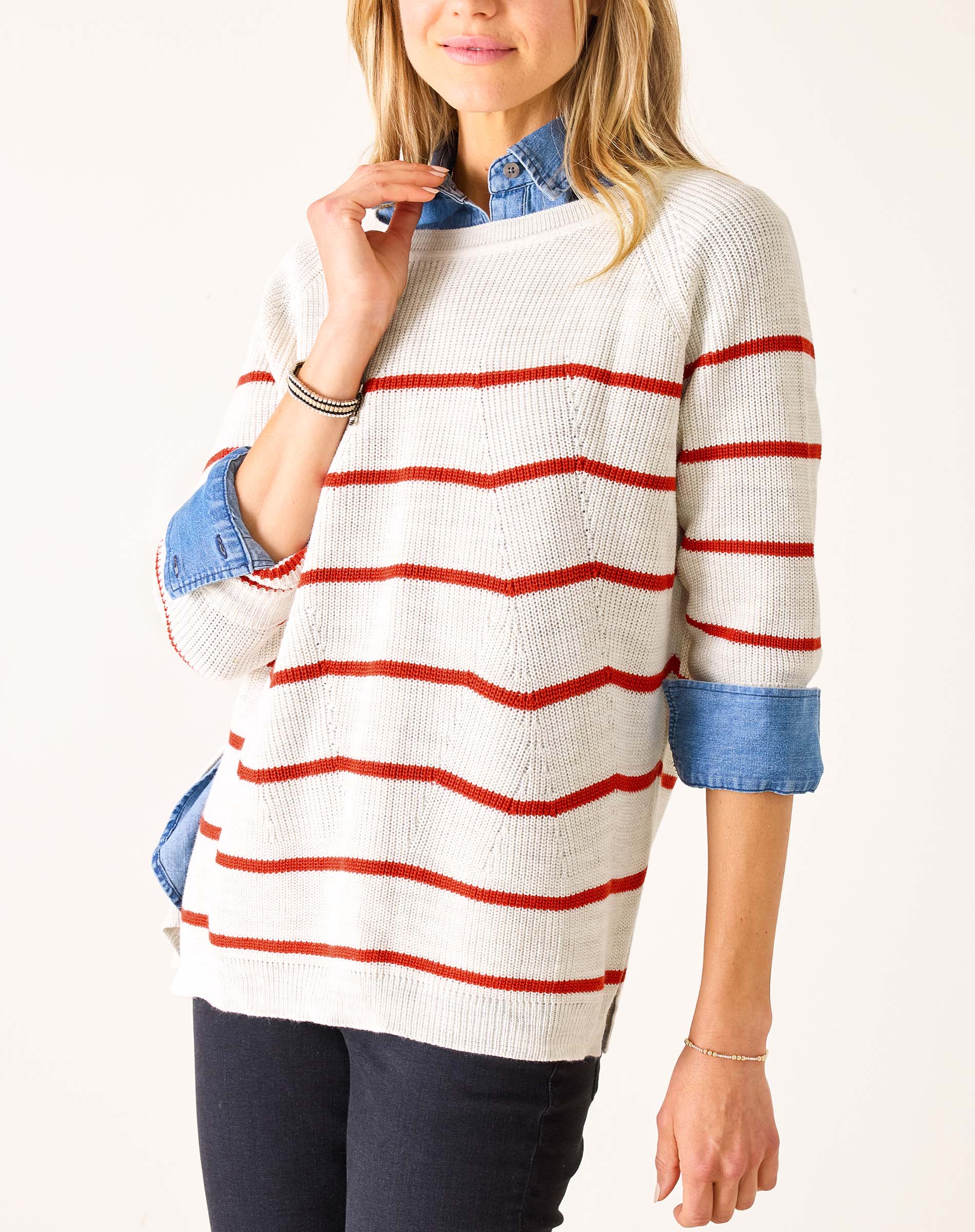 Person wearing a white sweater with red stripes on a white background