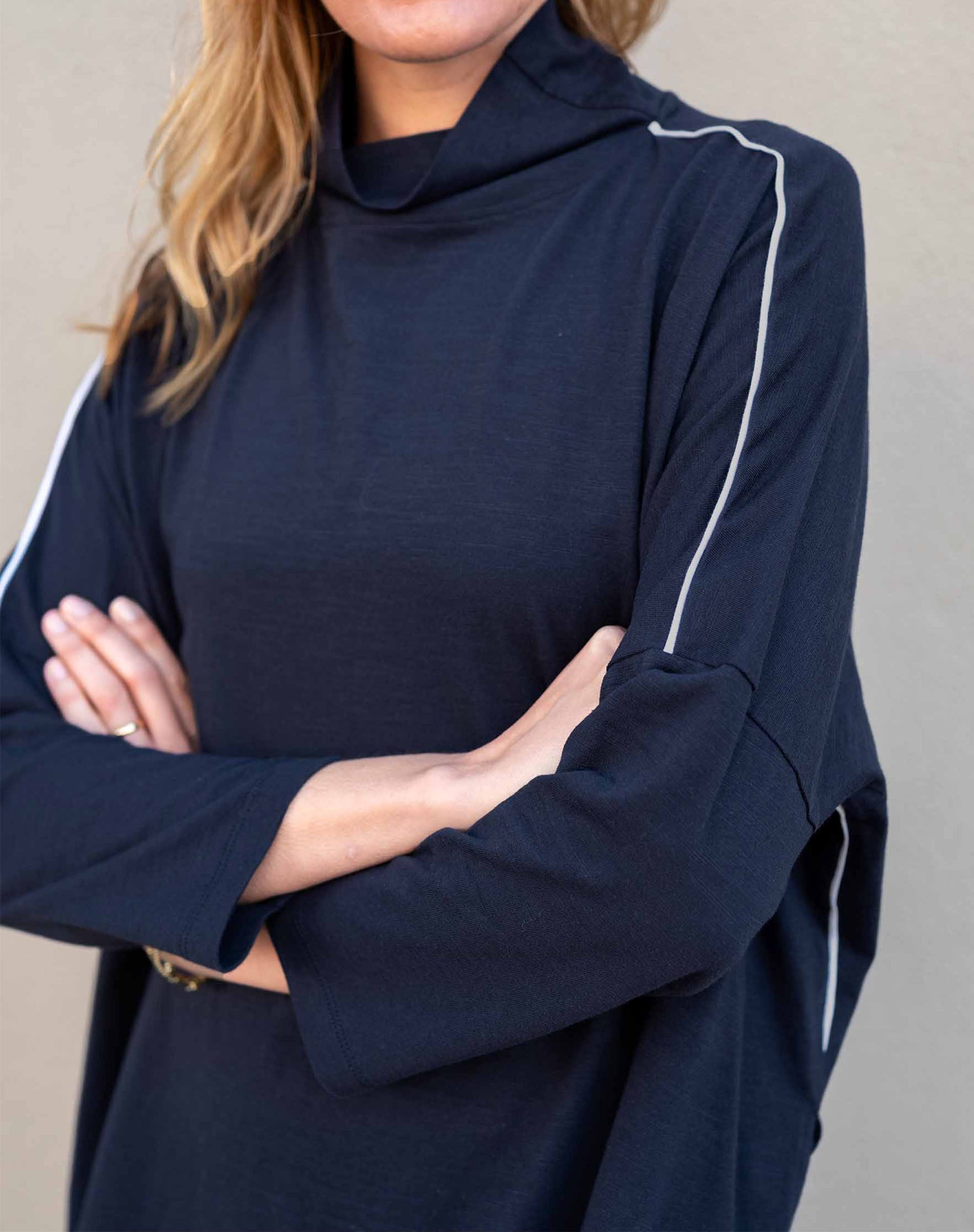 Navy blue long-sleeve top with white accents worn by a person against a neutral background
