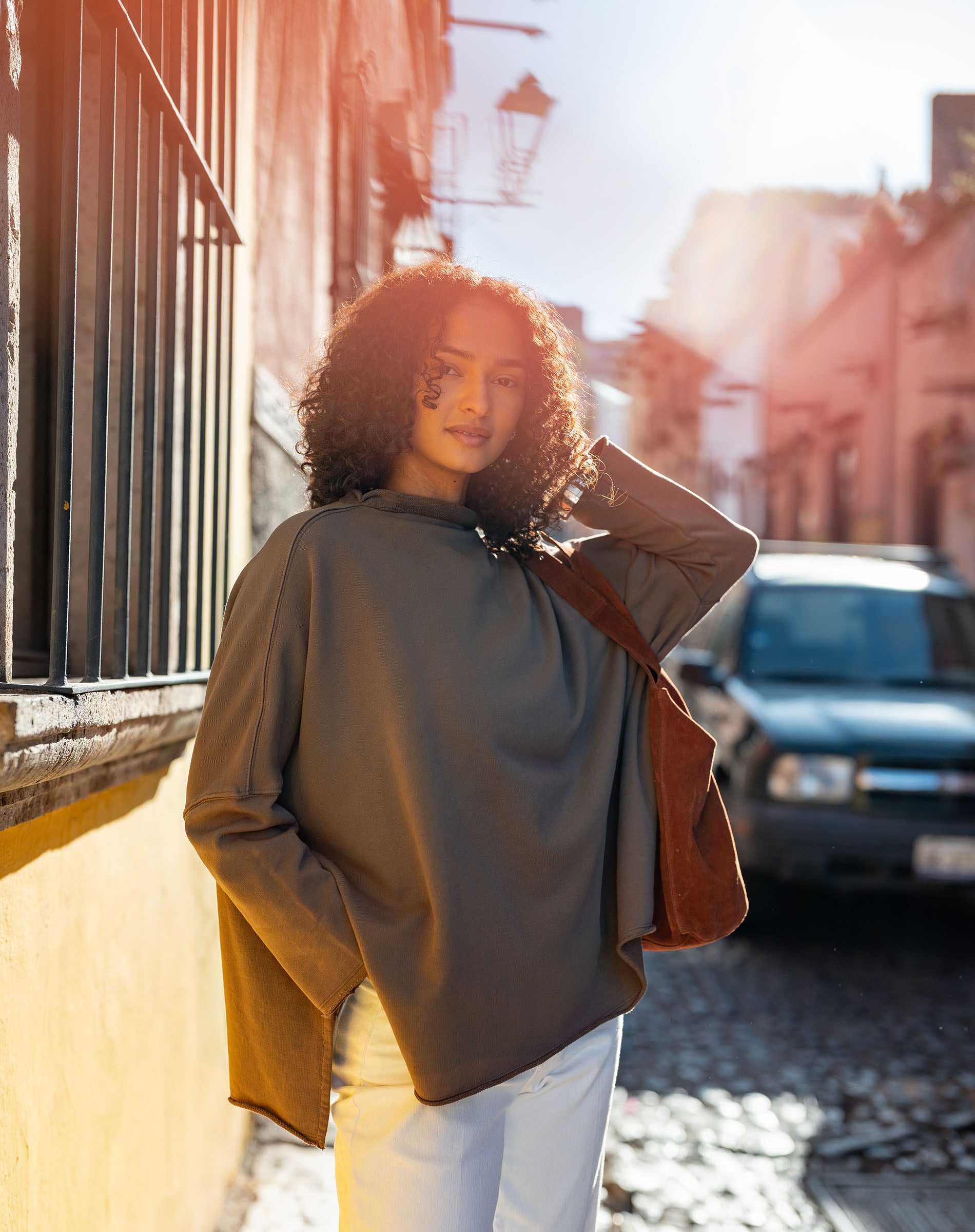 Woman standing on a street with sunlight and blurred background