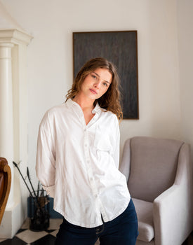 woman showcasing white mersea modern oxford tee button down standing in living room