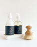 voyager shea lotion and liquid hand soap with brush laying on a white background