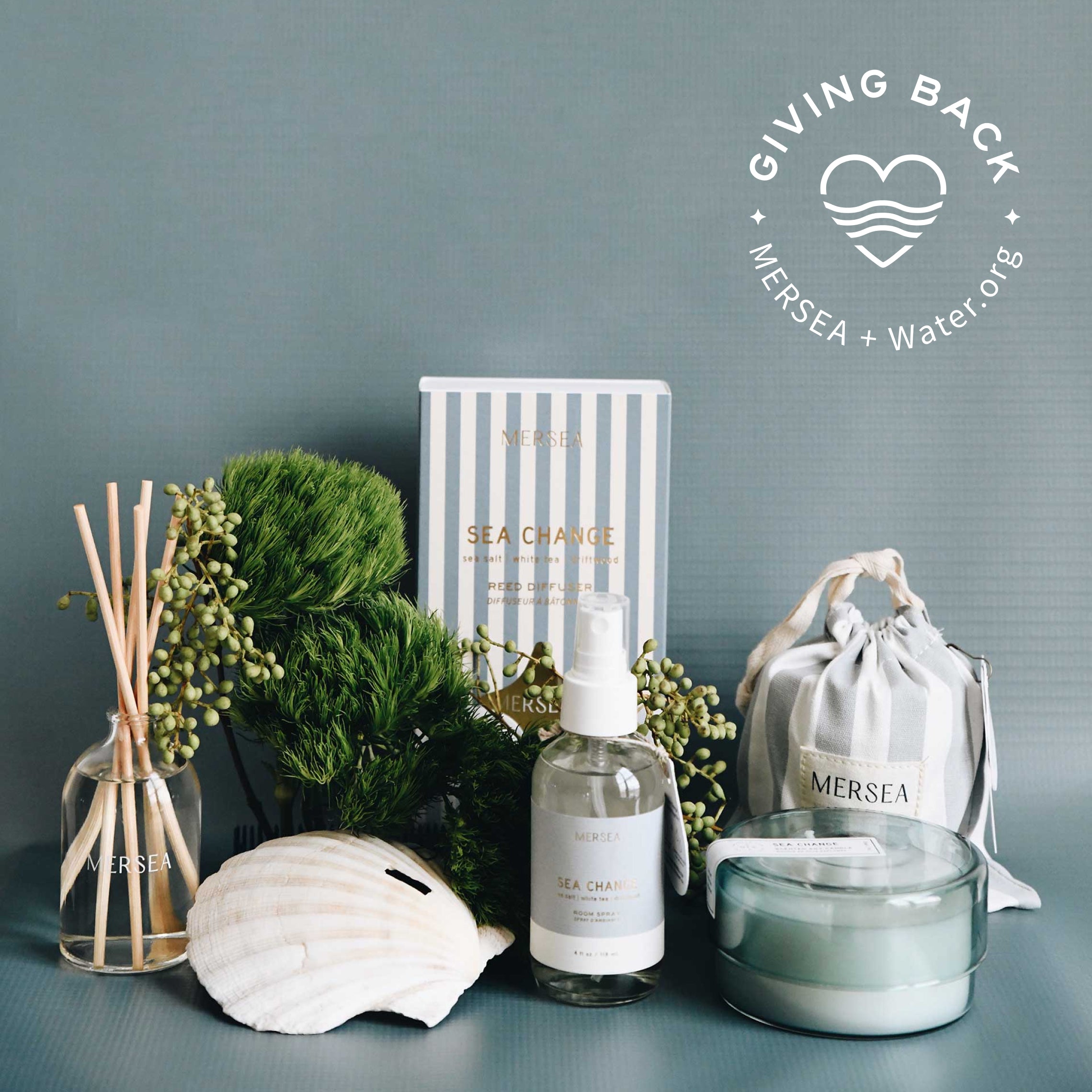 sea change scent in a diffuser, canister candle, room spray, sandbag candle on a grey background