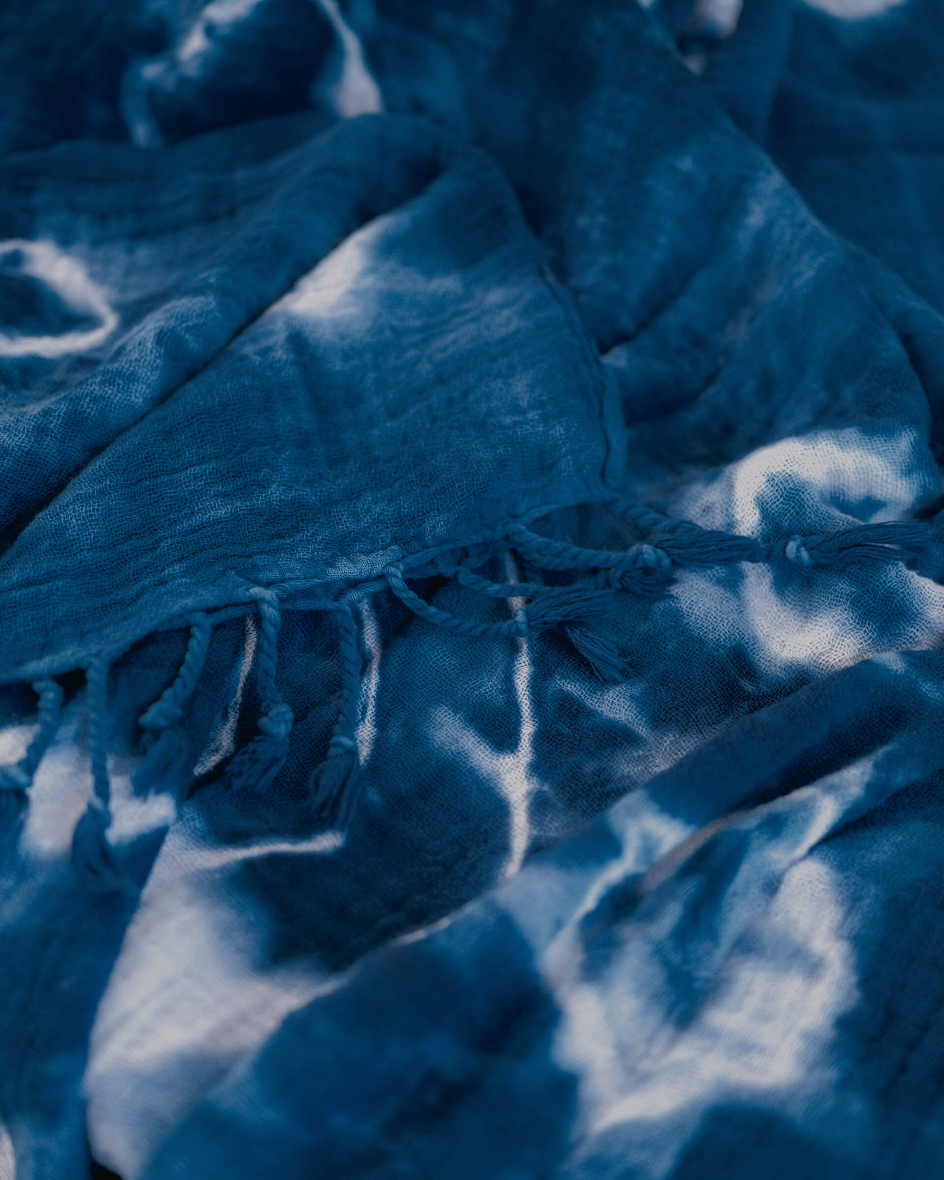 Summer House Blanket in Indigo Shiboriclose up of dark blue and white hand-dyed shibori blanket with fringe 