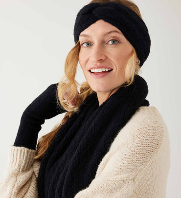 female wearing black fuzzy headband with matching fingerless gloves and scarf with white sweater