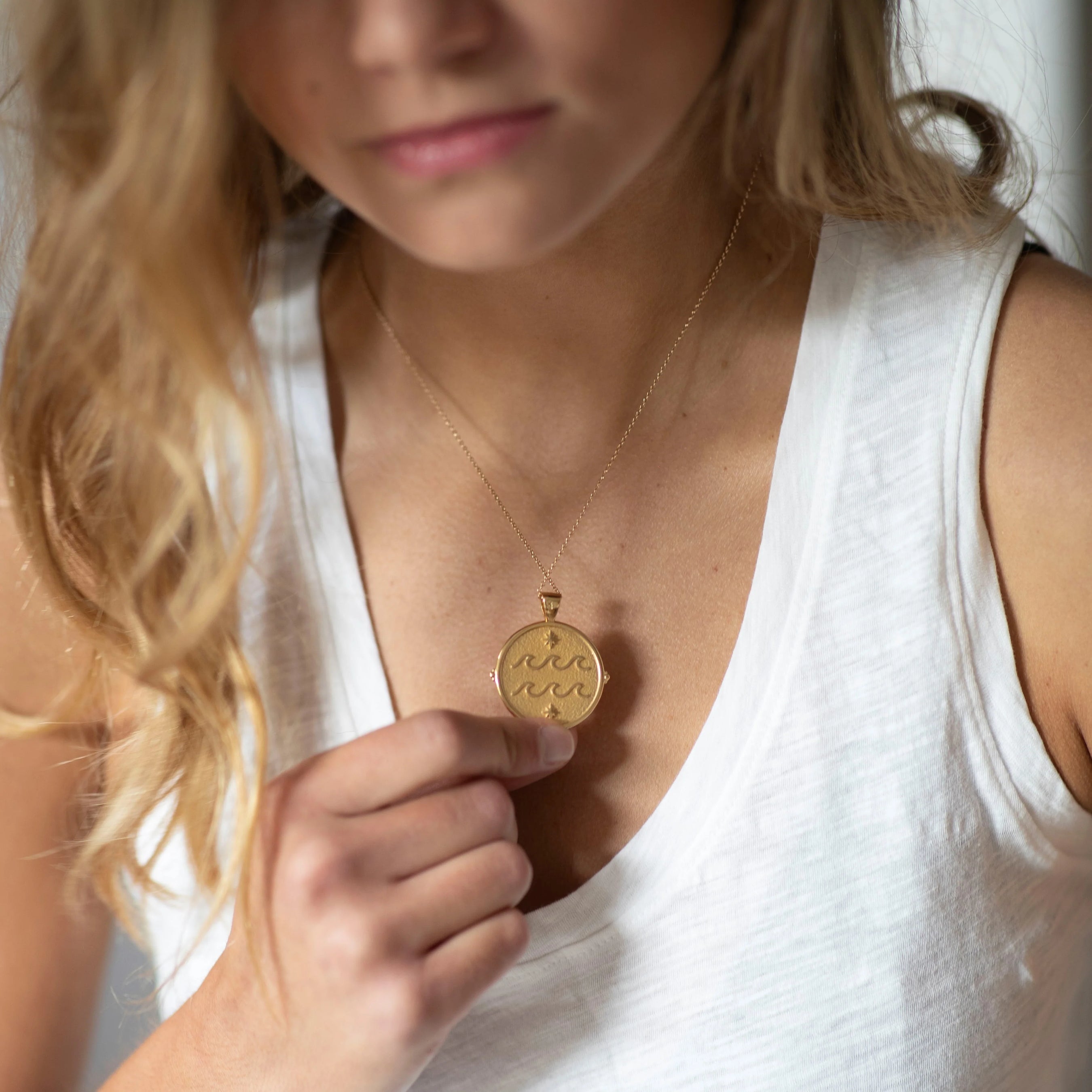 woman wearing mersea colab Aquarius zodiac pendant
