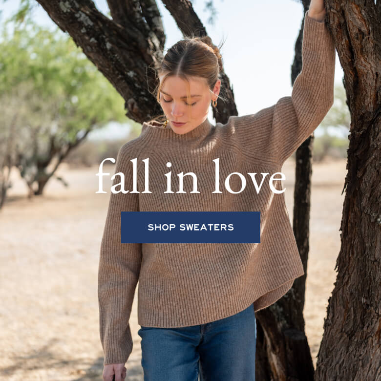 Woman wearing a brown sweater with 'fall in love' text and 'Shop Sweaters' button.
