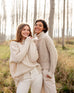 two Women, one wearing a sea salt Mersea Beachside Turtleneck sweater standing in forest