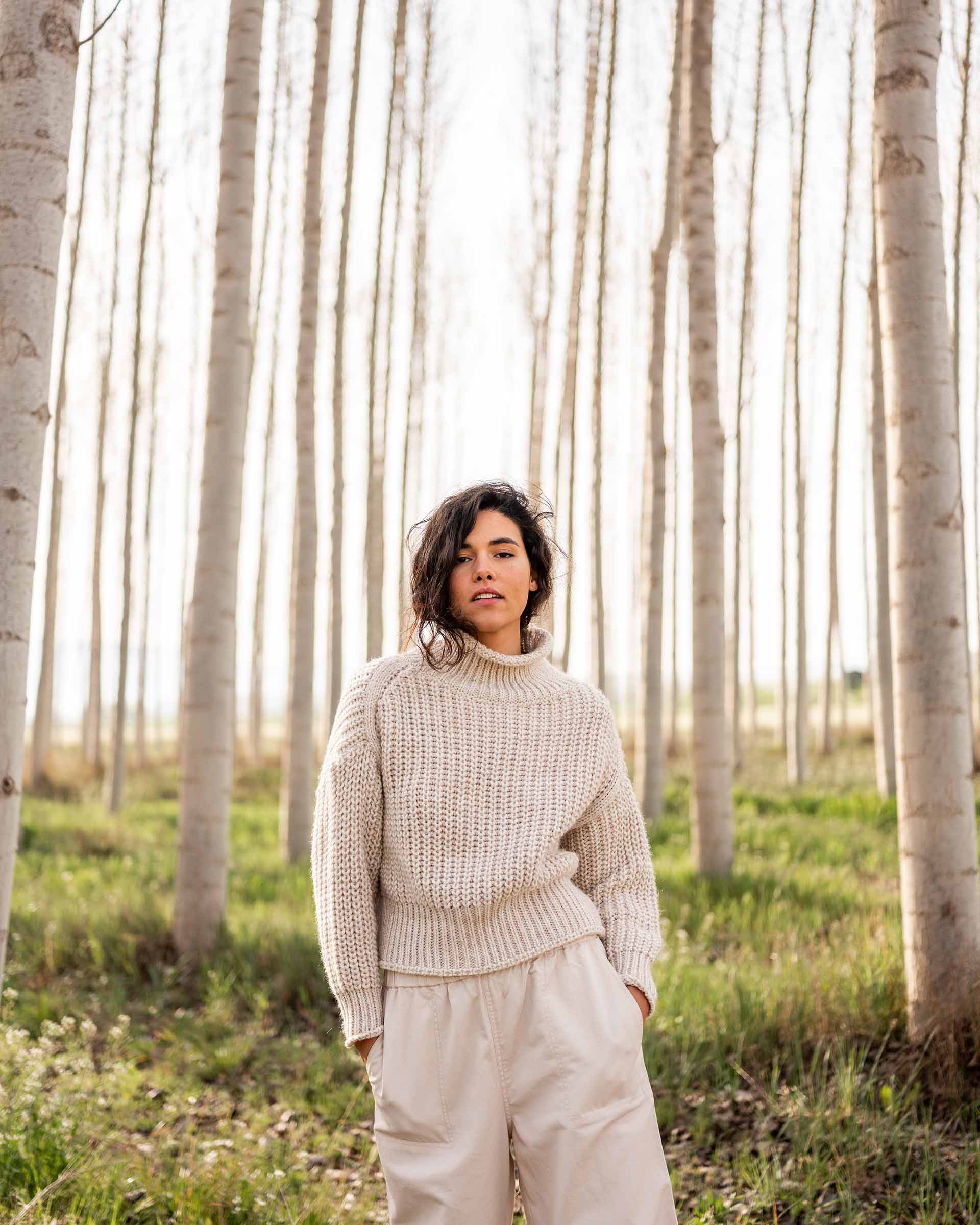 Women wearing a sea salt Mersea Beachside Turtleneck sweater standing in forest