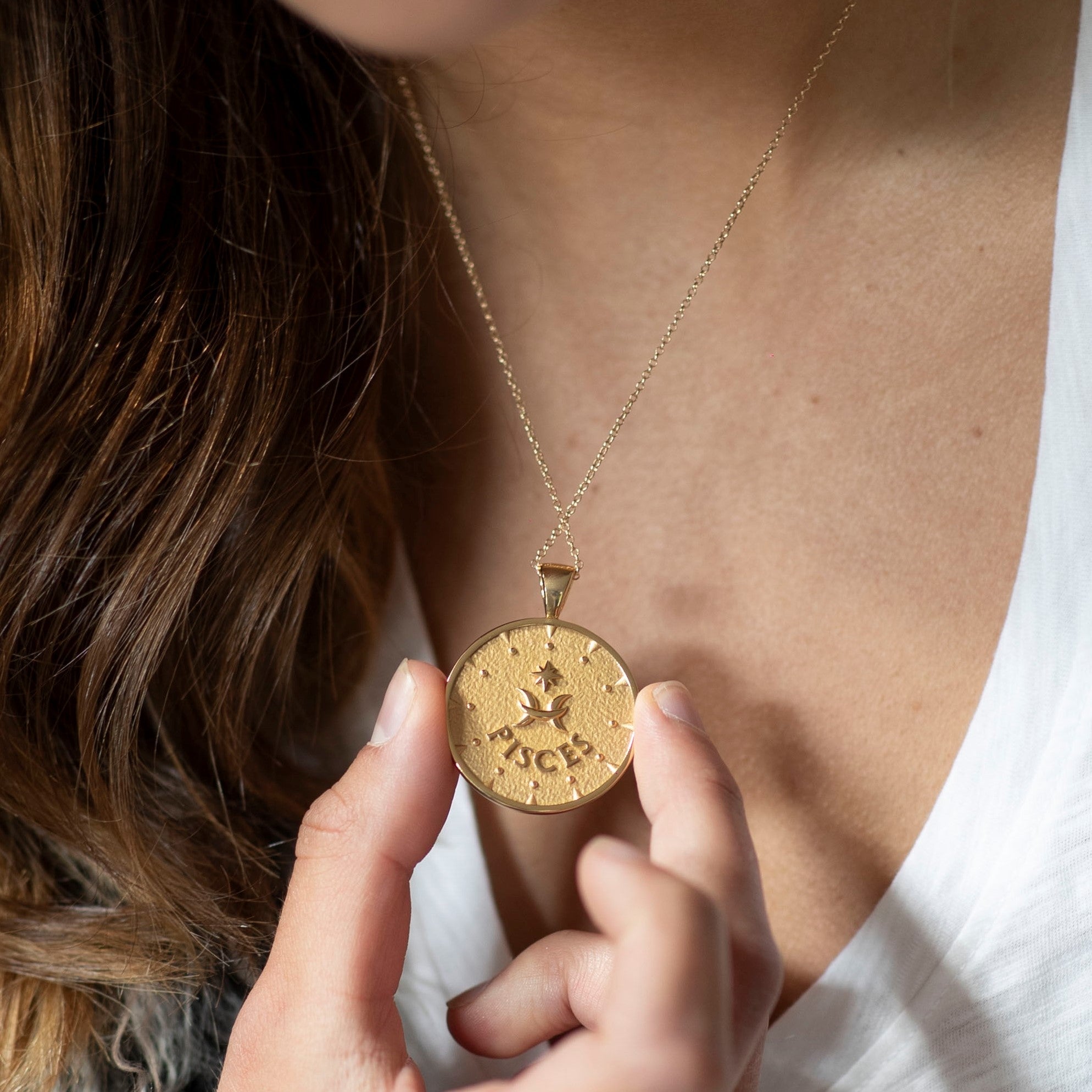 woman wearing mersea colab pisces zodiac pendant with chain