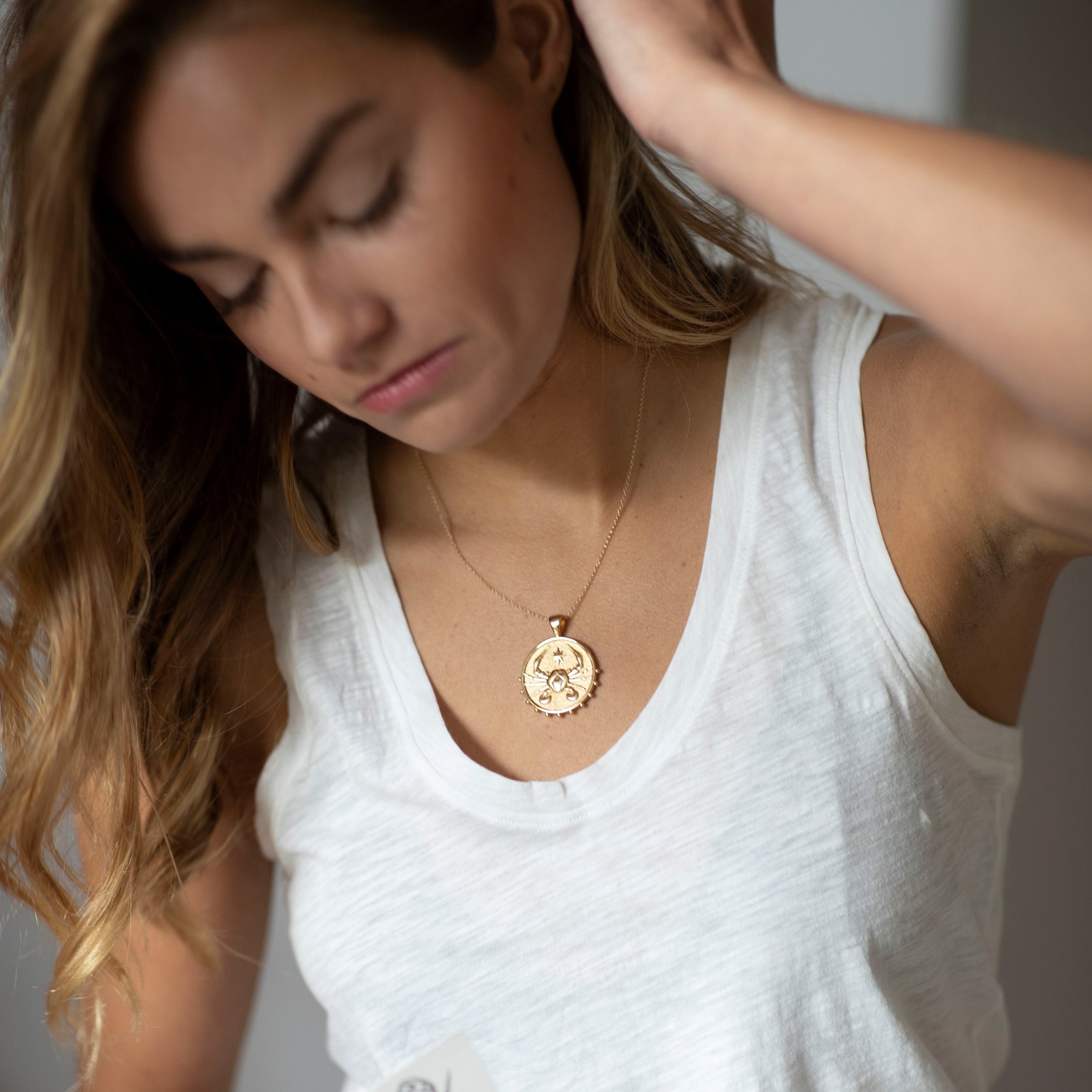 woman wearing mersea colab cancer zodiac pendant with chain
