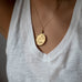 woman wearing mersea colab Leo zodiac pendant