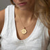 woman wearing mersea colab sagittarius zodiac pendant with chain