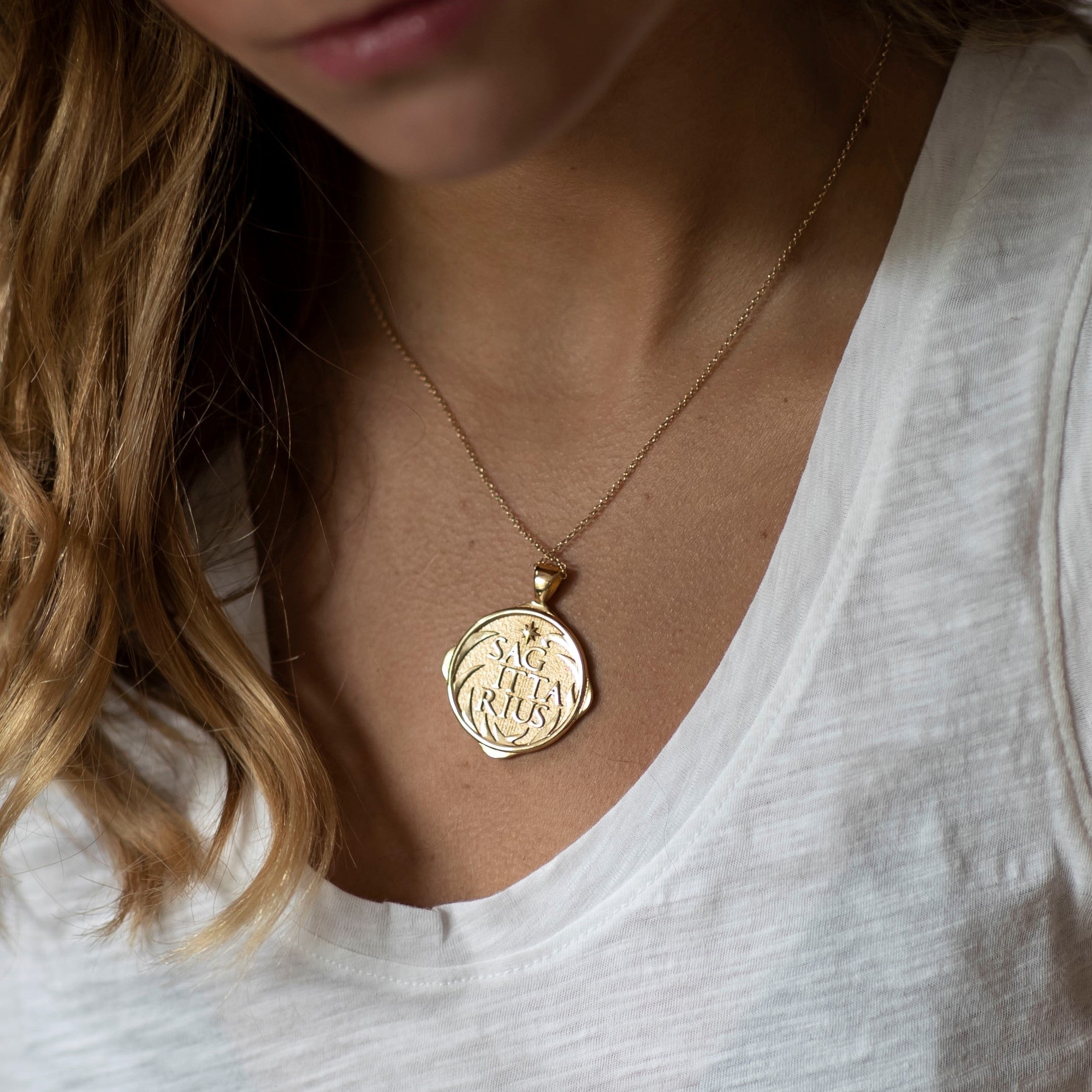 woman wearing mersea colab sagittarius zodiac pendant with chain