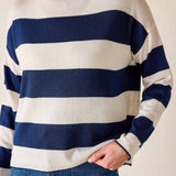 Person wearing a blue and white striped sweater with a neutral background