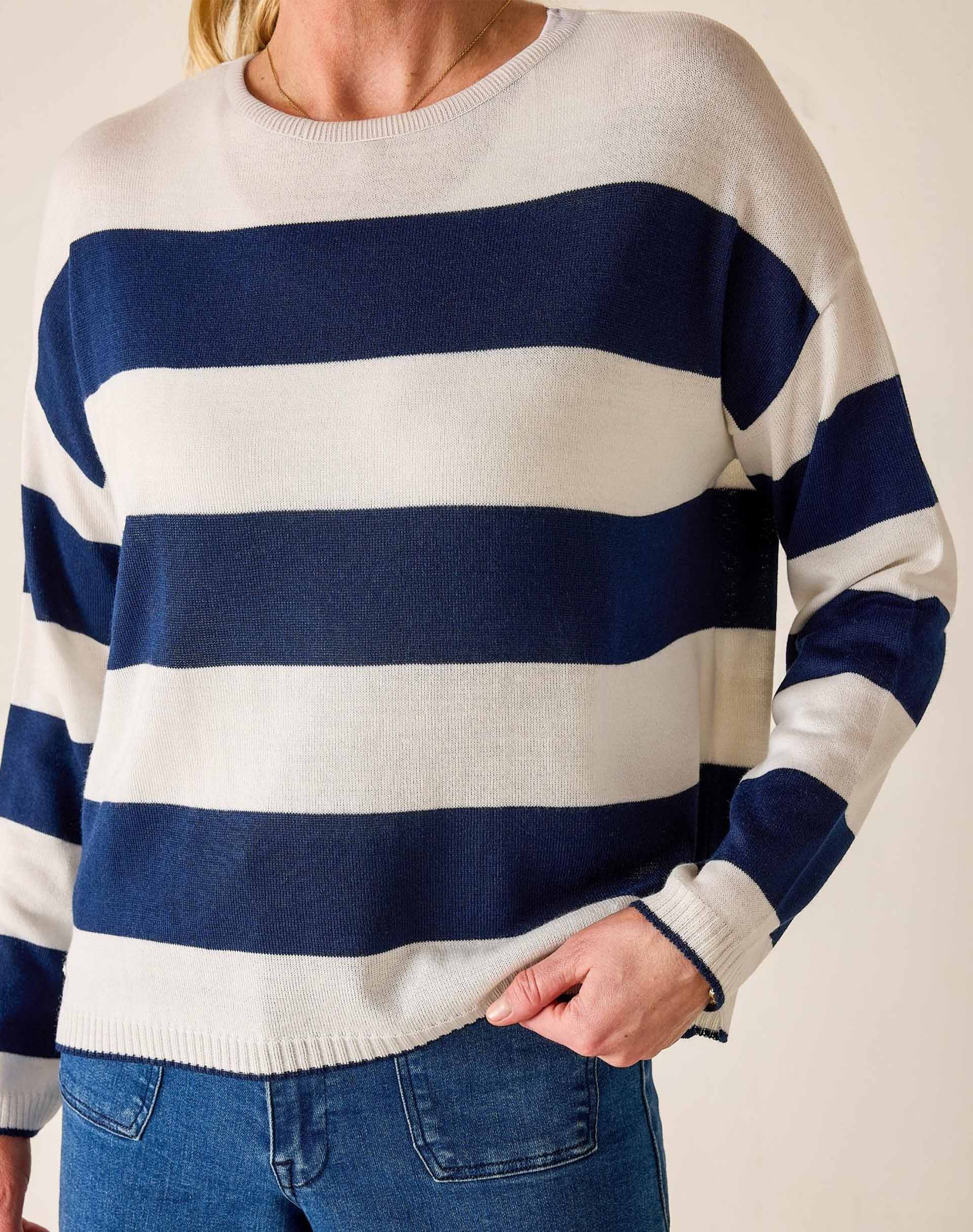 Person wearing a blue and white striped sweater with a neutral background