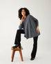 female wearing mersea storm catalina sweater standing with right foot on wooden stool