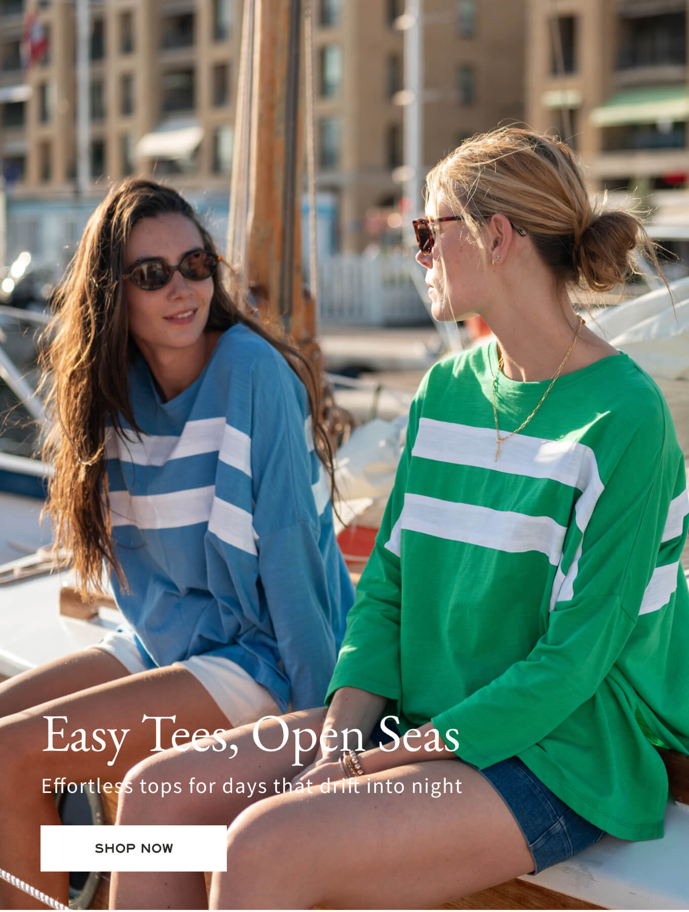 Two women sitting on a boat wearing colorful tops with text overlay.
