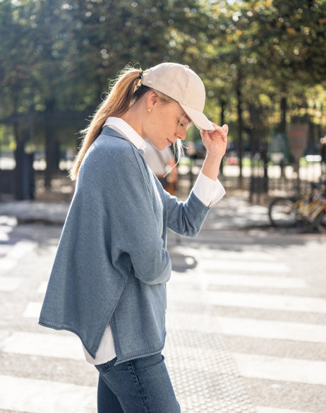 Image of a woman wearing a blue cotton sweater with side slits.