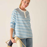 Woman wearing a blue and white striped sweater with a plain background
