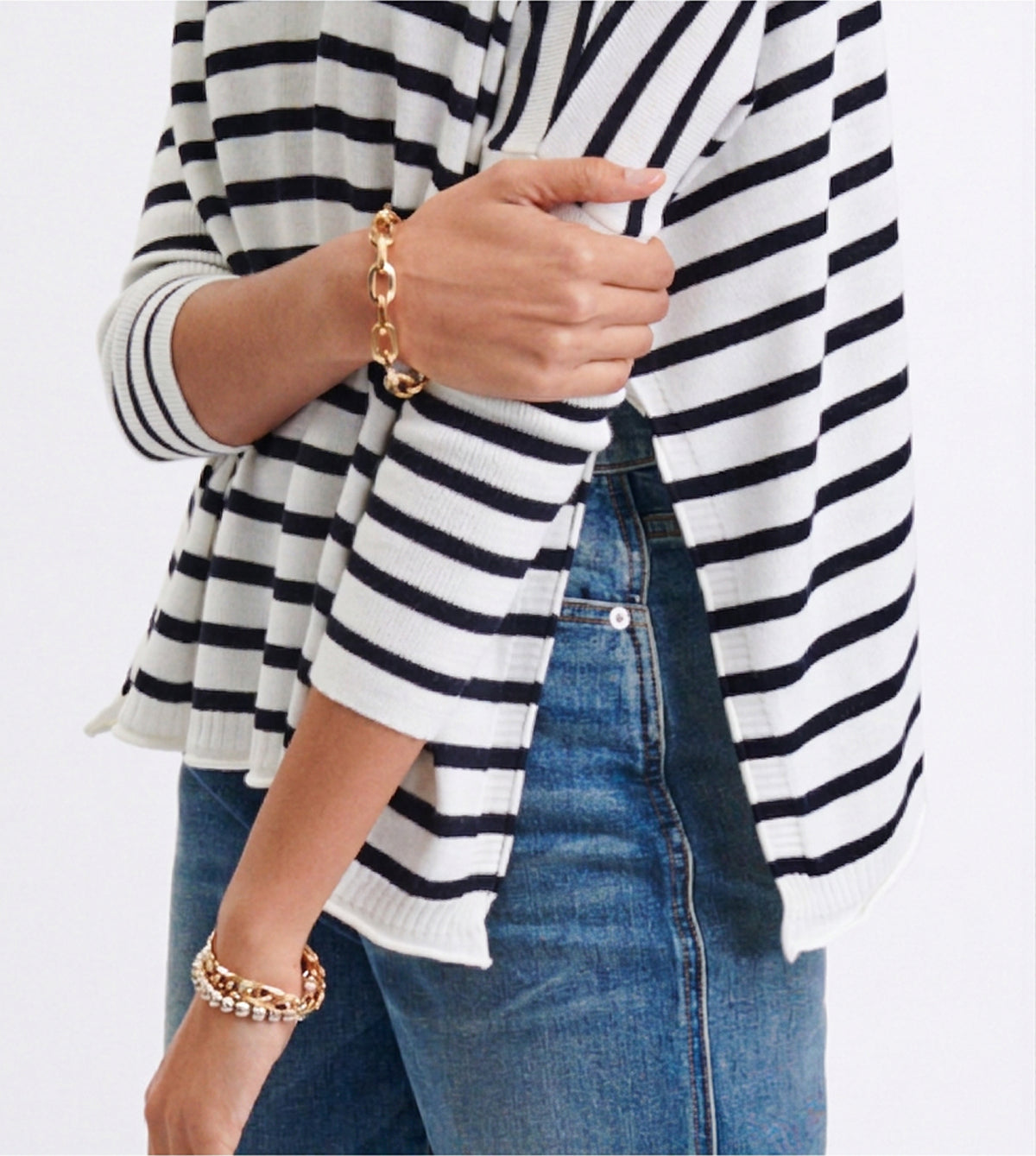 Navy and white striped knit sweater with gold link chain bracelets.