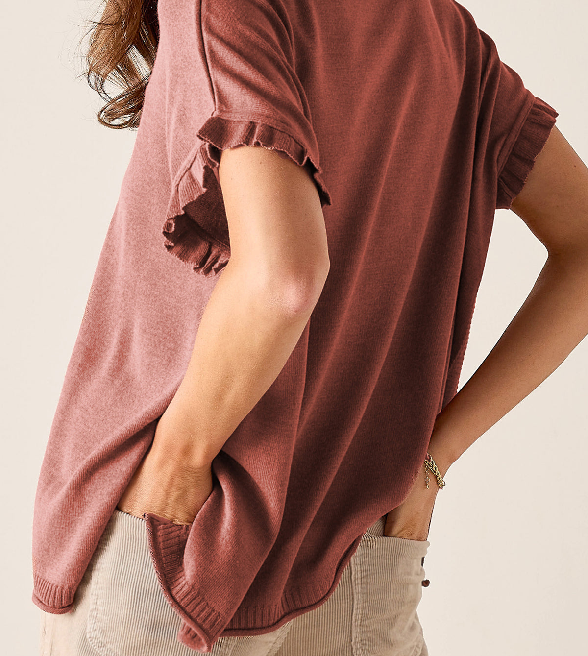 Dusty rose knit tunic with ruffled short sleeves.