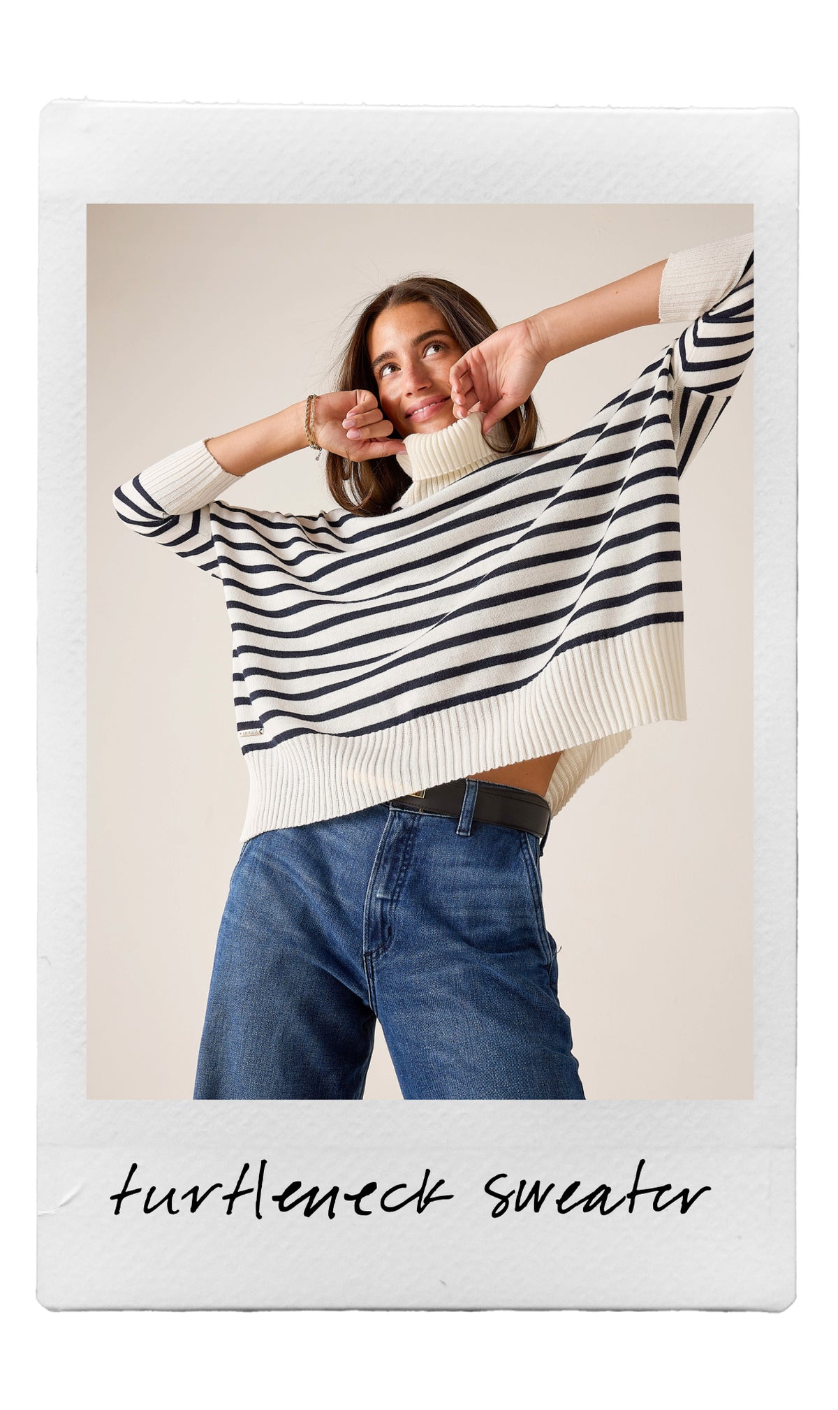 Cream and navy stripe ribbed knit turtleneck sweater with wide sleeves.