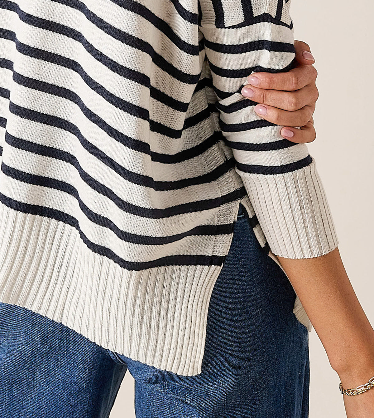 Cream and black striped knit turtleneck sweater with ribbed cuffs and hem.