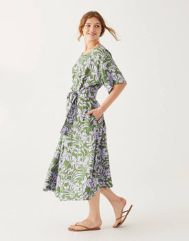 female wearing midi linen green dress with purple floral print on a white background