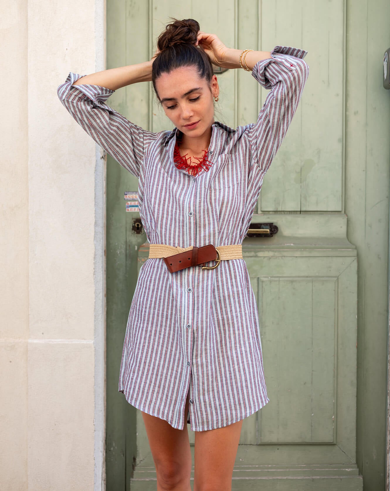 Image of a woman wearing a red and blue striped shirt dress.