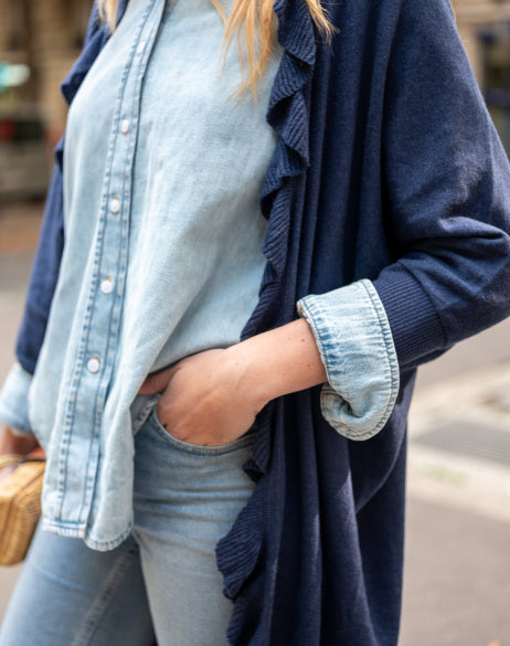 Close up image of a woman wearing a dark blue kimono with ruffle details.
