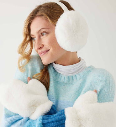 female wearing white earmuffs and matching gloves with a striped sweater on a white background
