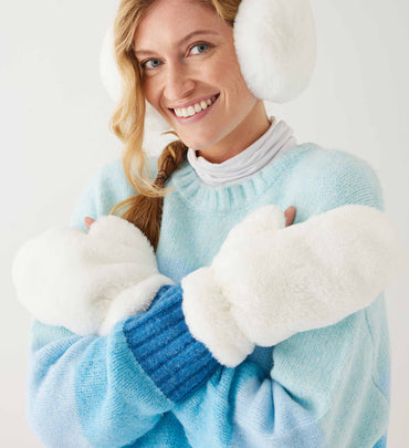 female wearing white earmuffs and matching gloves with a striped sweater on a white background