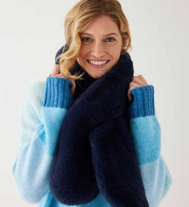 female wearing navy faux fur scarf with blue striped sweater on a white background