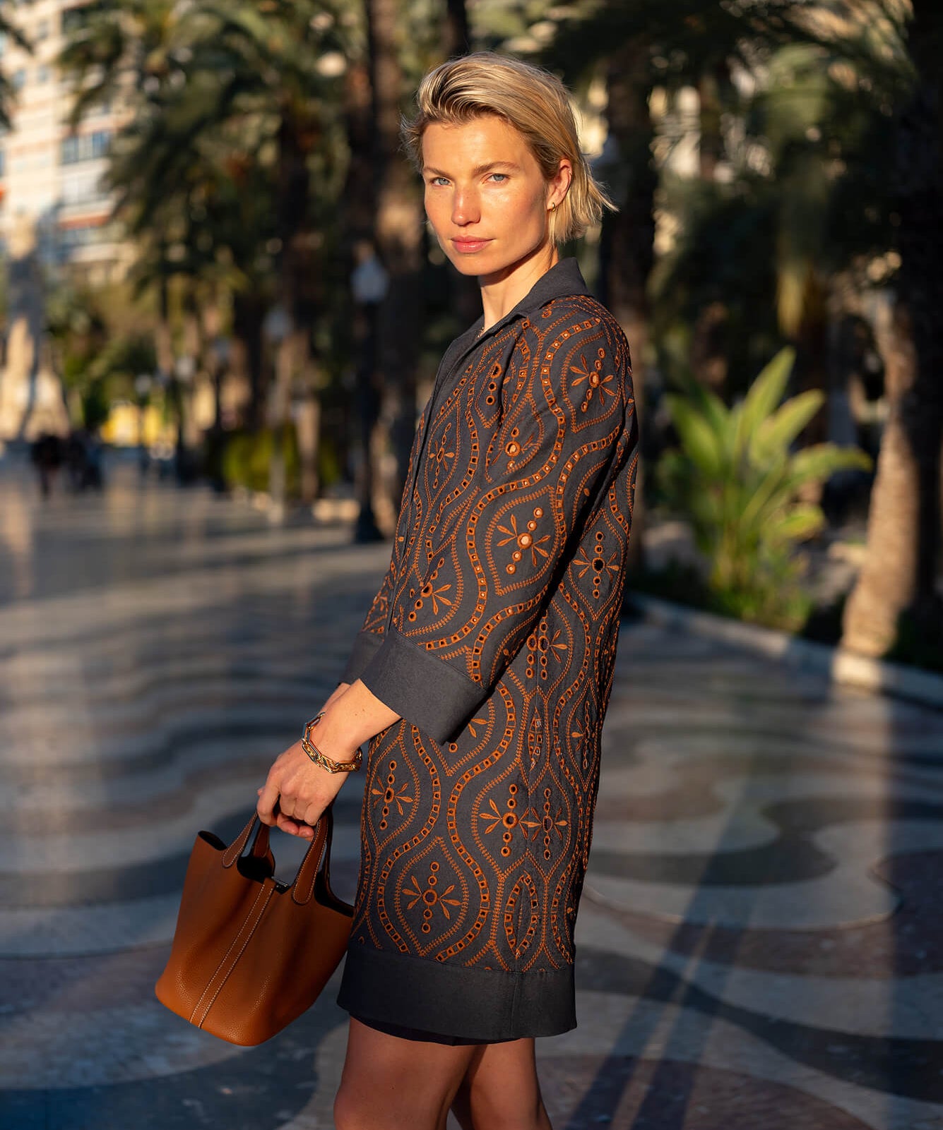 Navy and orange patterned knit tunic dress with three-quarter sleeves.