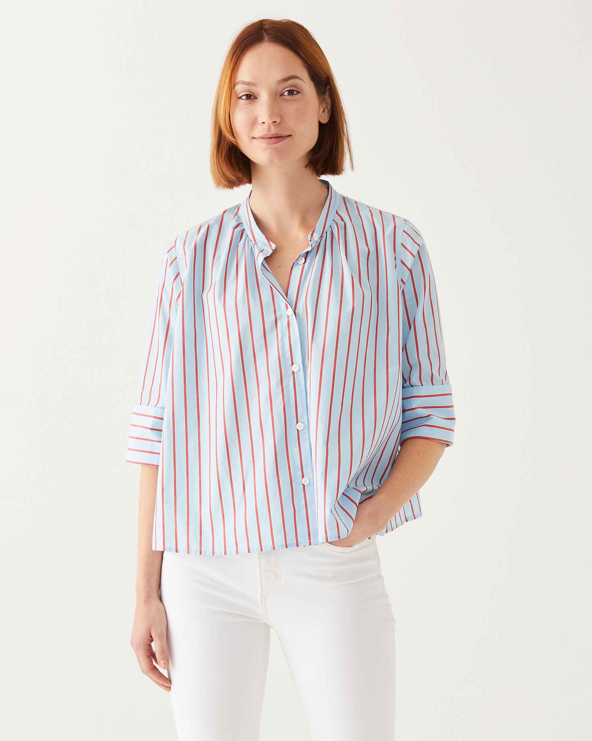 female wearing blue and red striped button-down shirt with editor cuff's on a white background