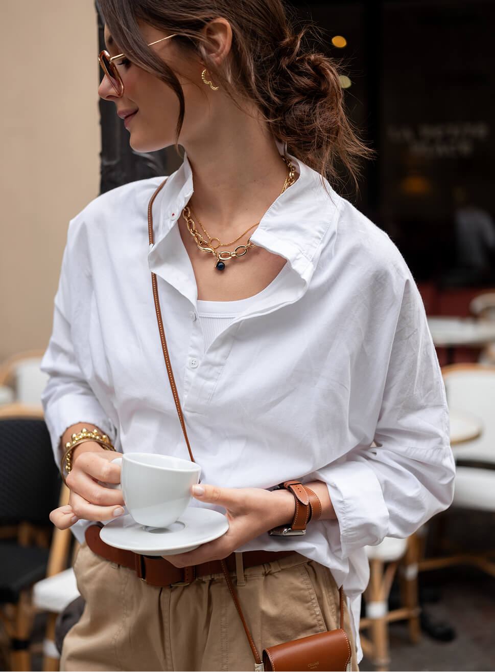 Image of a woman wearing a white top with a pop-up collar