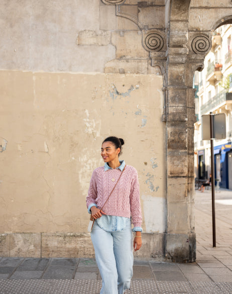 Image of a woman wearing a light pink cable-knit sweater