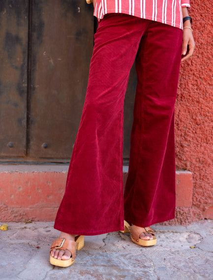 Close up image of a woman wearing red corduroy  wide leg pants