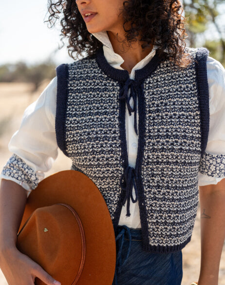 Person wearing a navy and white patterned vest outdoors