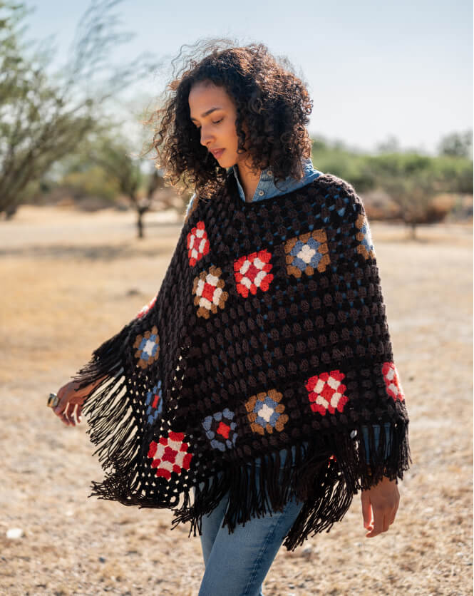 Woman wearing a colorful crochet poncho in a desert setting