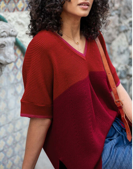Woman wearing a red and orange patterned sweater with a textured background