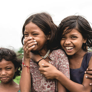 Three young girls are laughing looking at the camera