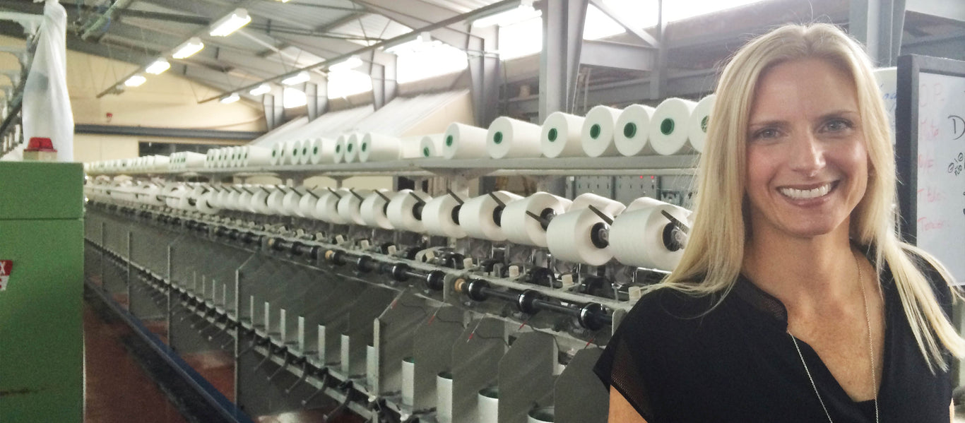 Lina our founder smiling in front of the machine that makes all of our products made in Ecuador