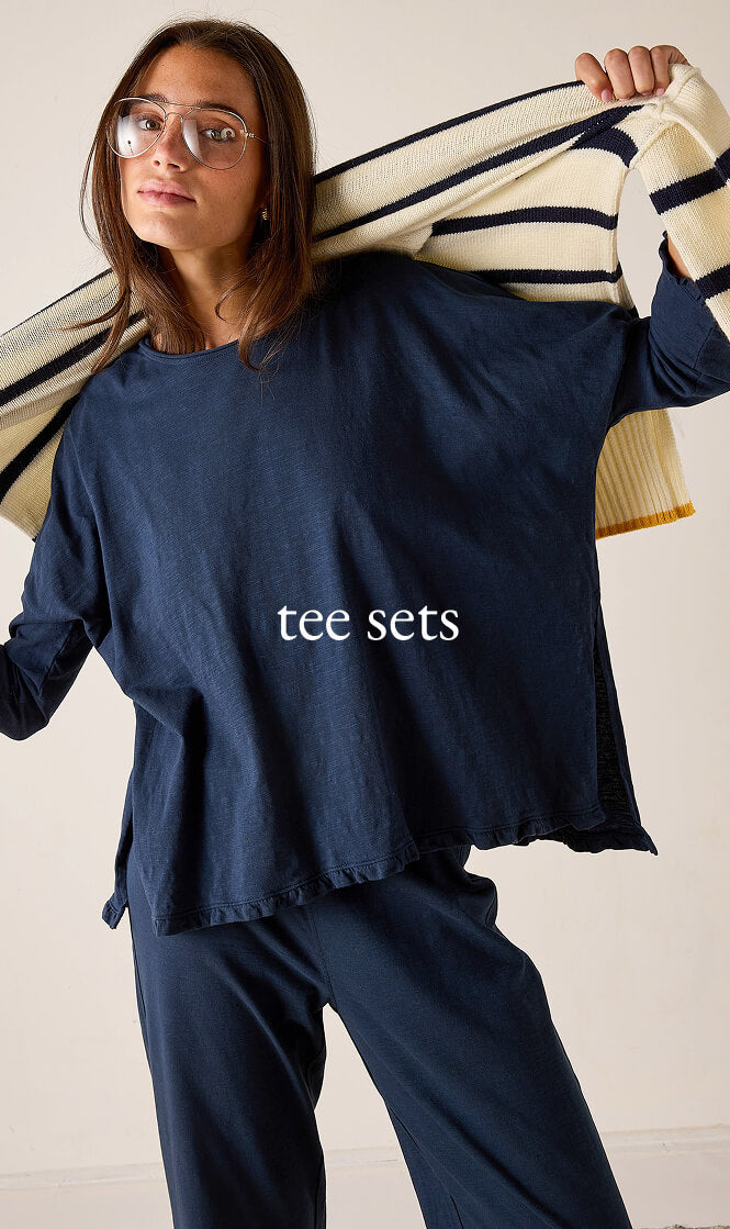 Ladies' travel-ready navy blue oversized knit top with long sleeves and matching lounge pants. Text: tee sets