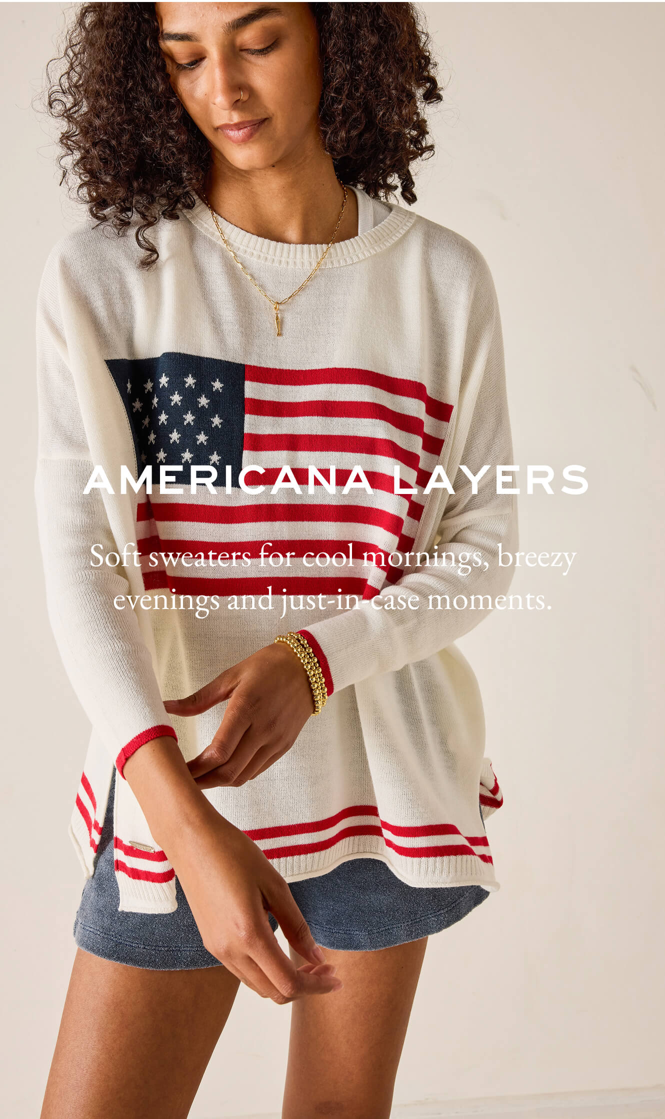 Woman wearing a sweater with an American flag design, text 'Americana Layers' on a beige background.