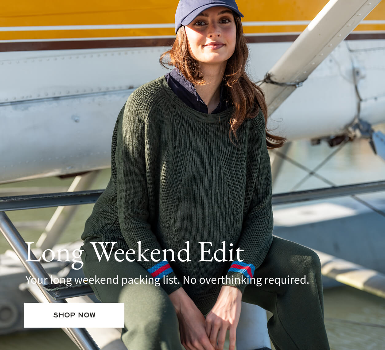 Long Weekend Edit - Your long weekend packing list. No overthinking required. - Image of a woman wearing a dark green crewneck sweater with red and blue details and matching pants
