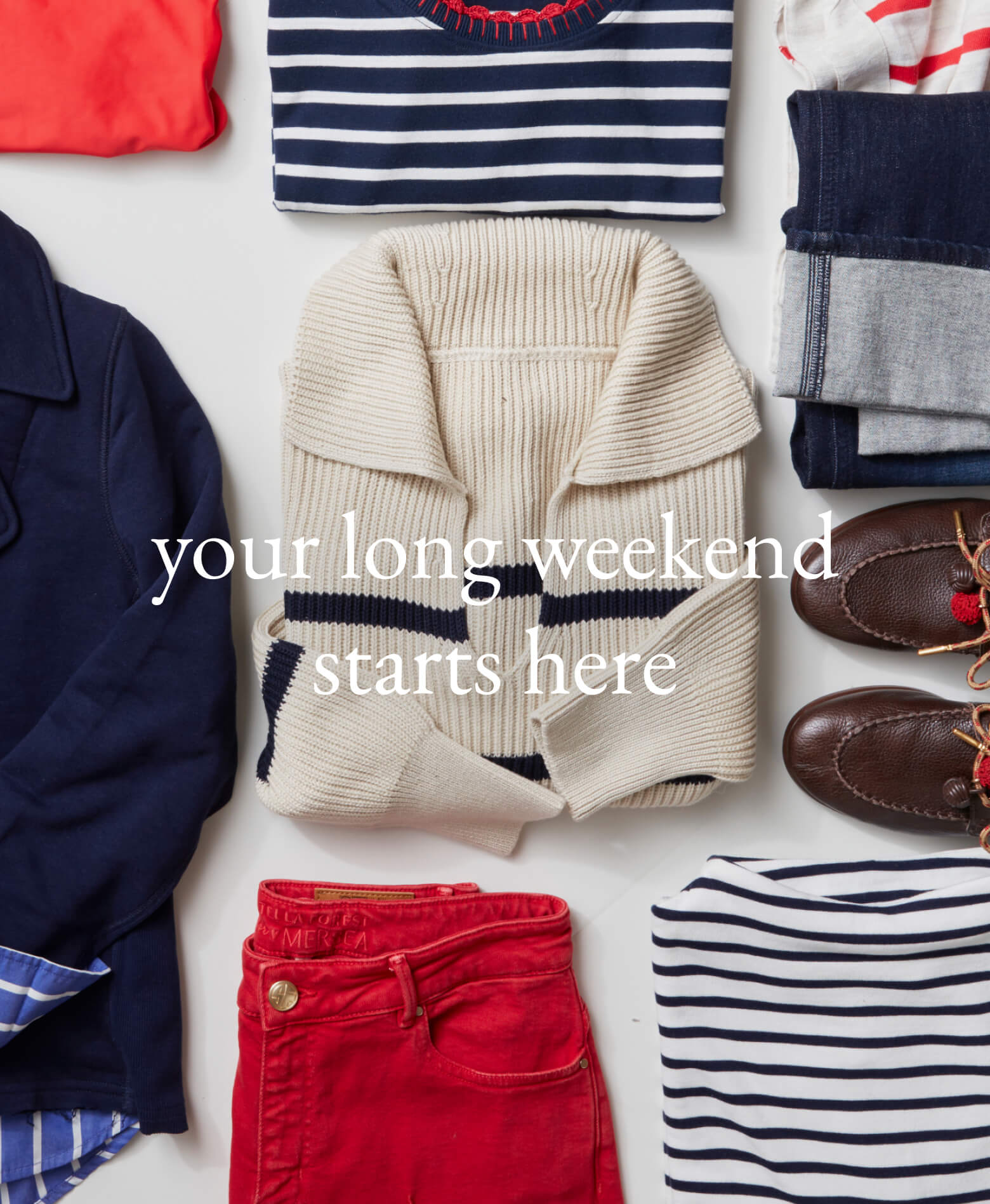 A collection of travel-friendly apparel including a navy coat, striped knits, and red bottoms laid out flat on a white surface. Text: 'your long weekend starts here'