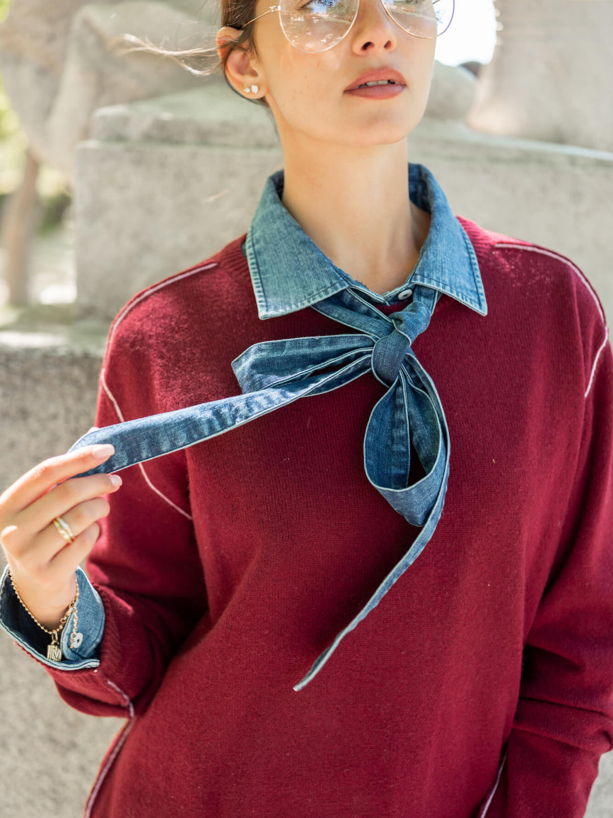 Burgundy knit sweater with a contrasting blue denim-style collar and large neck tie detail.