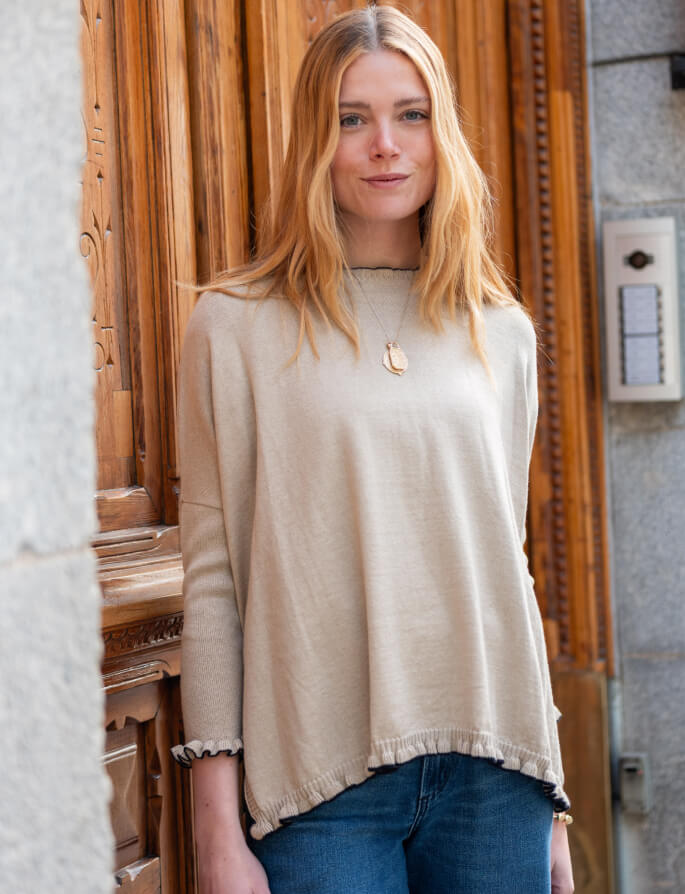 Sand-colored relaxed fit knit sweater with a draped hem and loose sleeves.